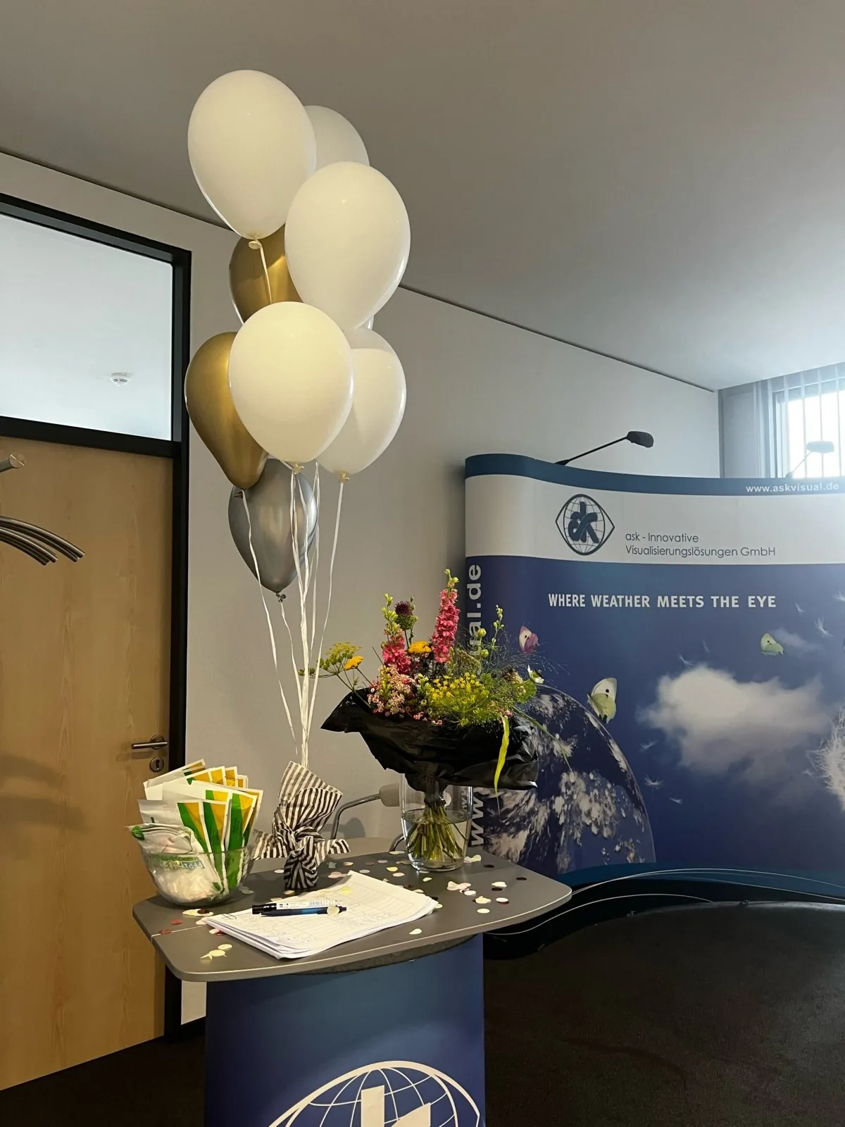 Office entrance decorated with balloons and flowers to welcome the team back