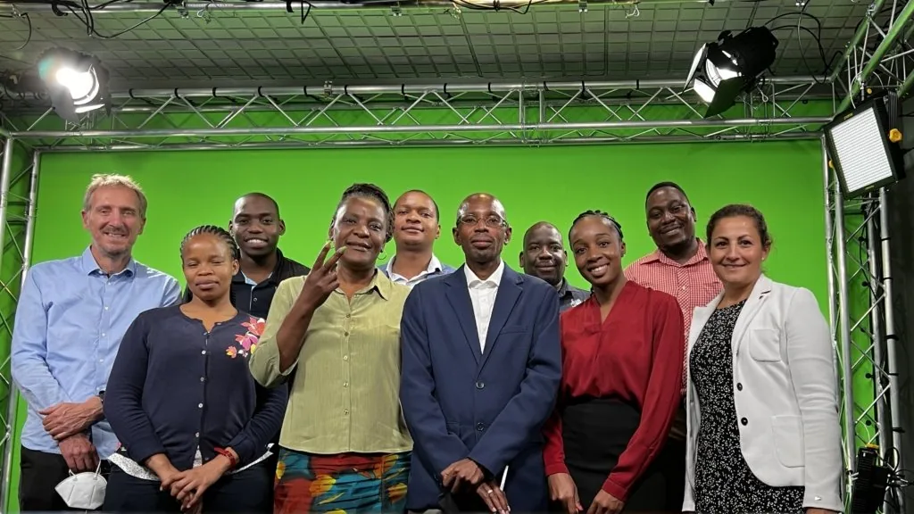 Group photo of the BDMS team and ask staff in front of the green screen in the TV studio